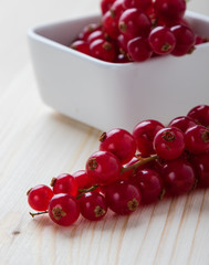 currant in white bowl on wooden table
