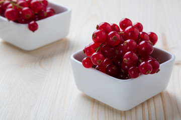 currant in white bowl on wooden table