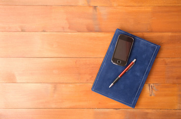 phone with a notebook on a wooden base