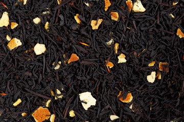 Background texture of black tea with orange peels.