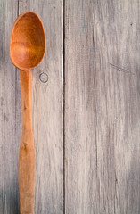 Old wooden spoon on a background of  boards