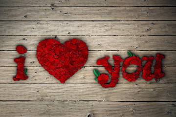 rose heart and i love you text made of red petals on a wooden surface background