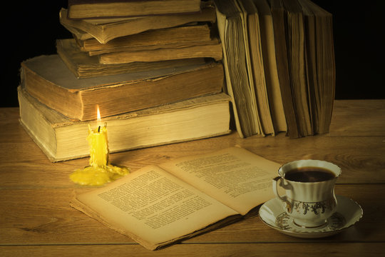 The old book, candle and a cup of coffee