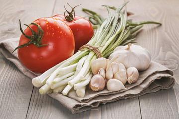 fresh vegetables on napkin over wood table, vintage toned