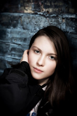 Tween girl on blue brick wall not smiling