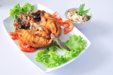 fired fish with fish sauce and spicy mango salad ,on white background