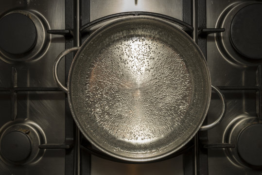 Boiling water for cooking in a metal pan on a stove , cooker