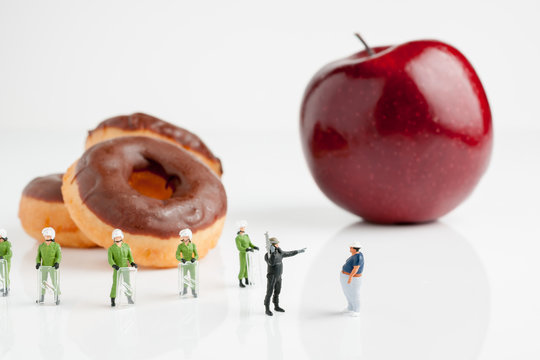 Eat an Apple Instead Tiny riot police telling a fat man to eat an apple instead of donuts an obesity concept