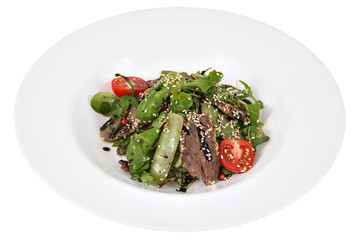 Salad with ruccola and thin cut beef on round dish.