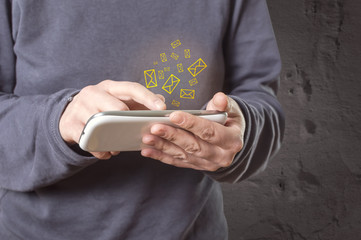 Hand holding smart phone, email icon appears on the screen of th