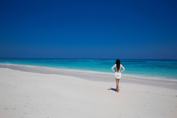 Enjoyment. Beautiful woman walking on exptic beach with white sa