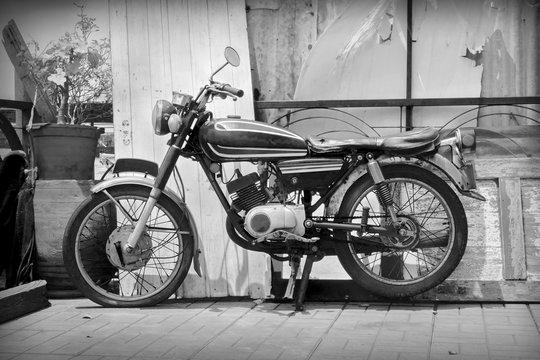 Old motorcycle / Old classic motorcycle parked on sidewalk. Black and white tone.