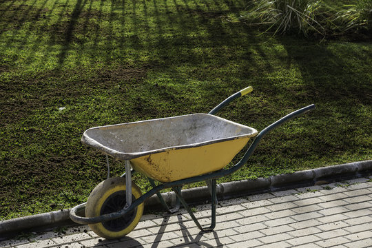 Single barrow close to the grass covered by fertilizer