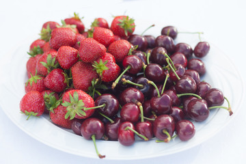 fresh strawberries and cherries on white