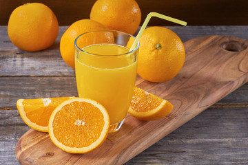 Orange juice on wooden table with sliced fruits