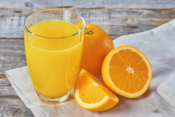 Orange juice on wooden table with sliced fruits