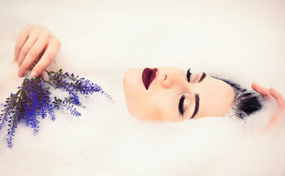 Woman With Flowers In The Foam Bath