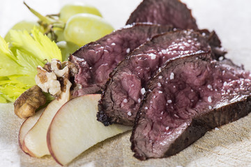 Beef steak slides with apples, walnuts and grapes