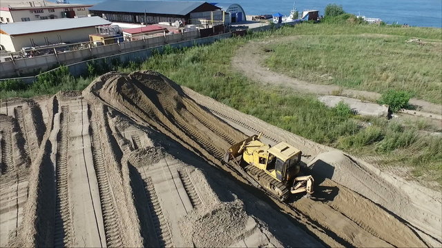 Flying over the building site. land preparation. Tractor pull earth