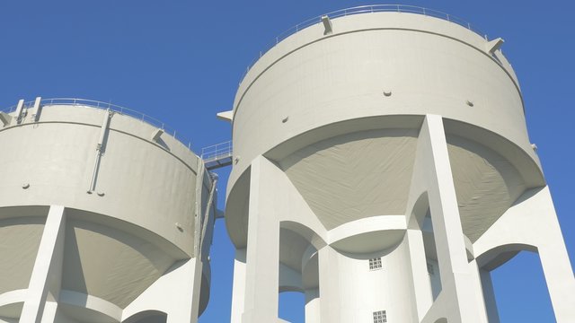 Water tank tower in front of blue sky 4K 3840X2160 UltraHD video - Water tower concrete slow panning 4K 2160p UHD footage 