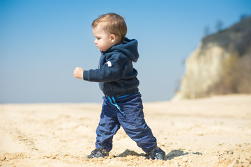 little boy walks on the beach