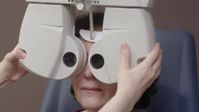 Senior female Caucasian patient has her eyesight examined by doctor in modern hospital