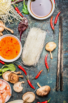 Chopsticks and Asian cooking ingredients and sauces on rustic background, top view. Chinese or Thai food concept