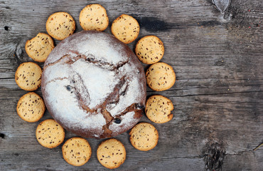 Loaf of bread and bisquits on old wooden table