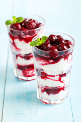 Dessert with cherry sauce in glass, selective focus
