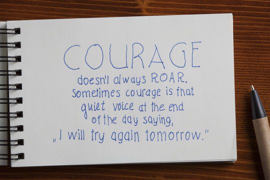 Courage handwritten text on a notebook with pen