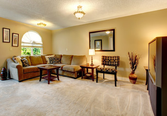 Living room with rounded window and sectional couch.