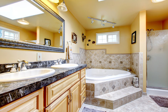 Luxury bathroom with jacuzzi style bath tub, stone floor, and bl