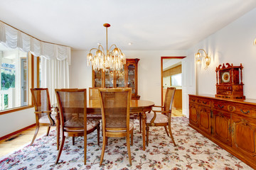 Dinning room with floral patterned rug, deep toned wood and chan