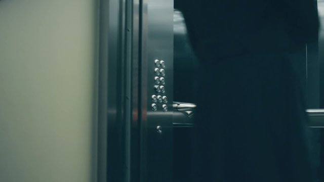 Business people call an elevator, get in when it arrives