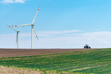 Windmills and tractor on the field