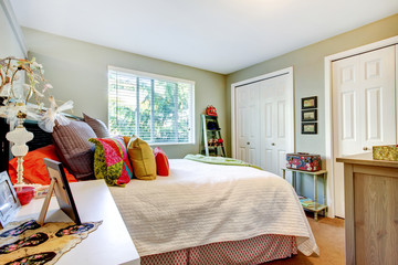 Young girl bedroom with dual closets, and white bedding.