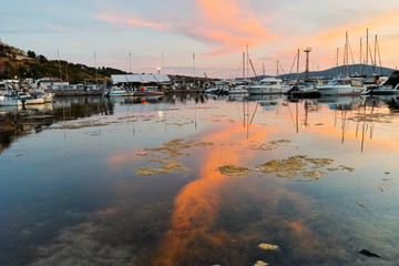 Reflection of red clouds in the water of port of Sozopol, Burgas Region, Bulgaria