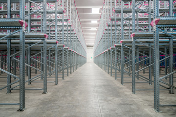 Rows of empty shelves in a big warehouse - obrazy, fototapety, plakaty