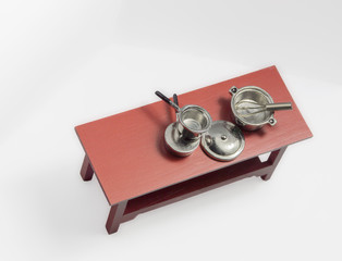 Variety of empty pots and pans sitting on wooden table with white background