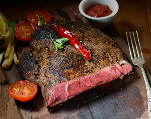 steak on the wooden background with roasted vegetables