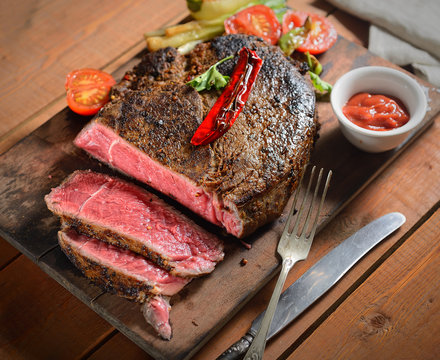 steak on the wooden background with roasted vegetables