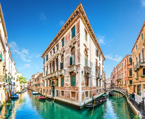 Fototapeta na wymiar Traditional Gondolas on narrow canal between colorful houses, Venice, Italy