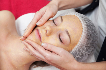 Woman having facial mask at beauty salon