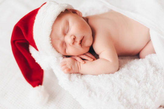 Child sleeps in a hat of Santa Claus