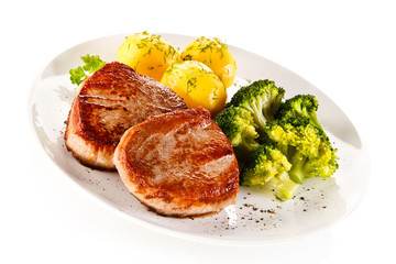 Grilled steaks, boiled potatoes and vegetable salad 
