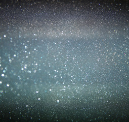 glitter vintage lights background. gold, silver, blue and black. de-focused.
