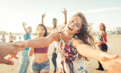 Foto op Aluminium Group of friends having fun and dancing on the beach © oneinchpunch