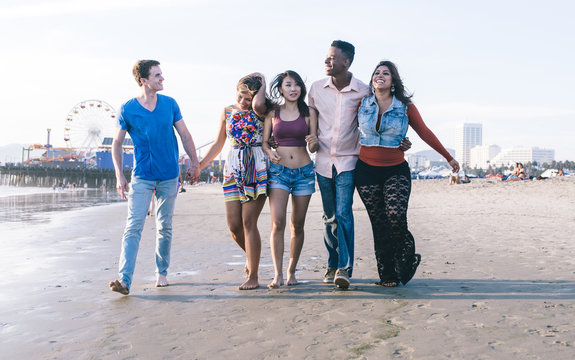 Mixed race group of friends walking in Santa monica beach