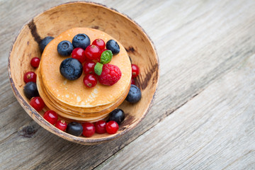 Stack of pancakes with blueberry and fresh berry.