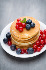 Stack of pancakes with blueberry and fresh berry.